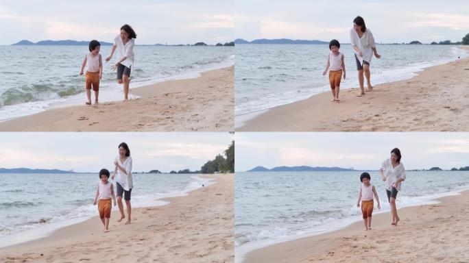 4岁的亚洲母亲和儿子的家庭在沙滩上沿着日落海浪的边缘奔跑并度过时光。家庭假期快乐。母亲节2020。轻