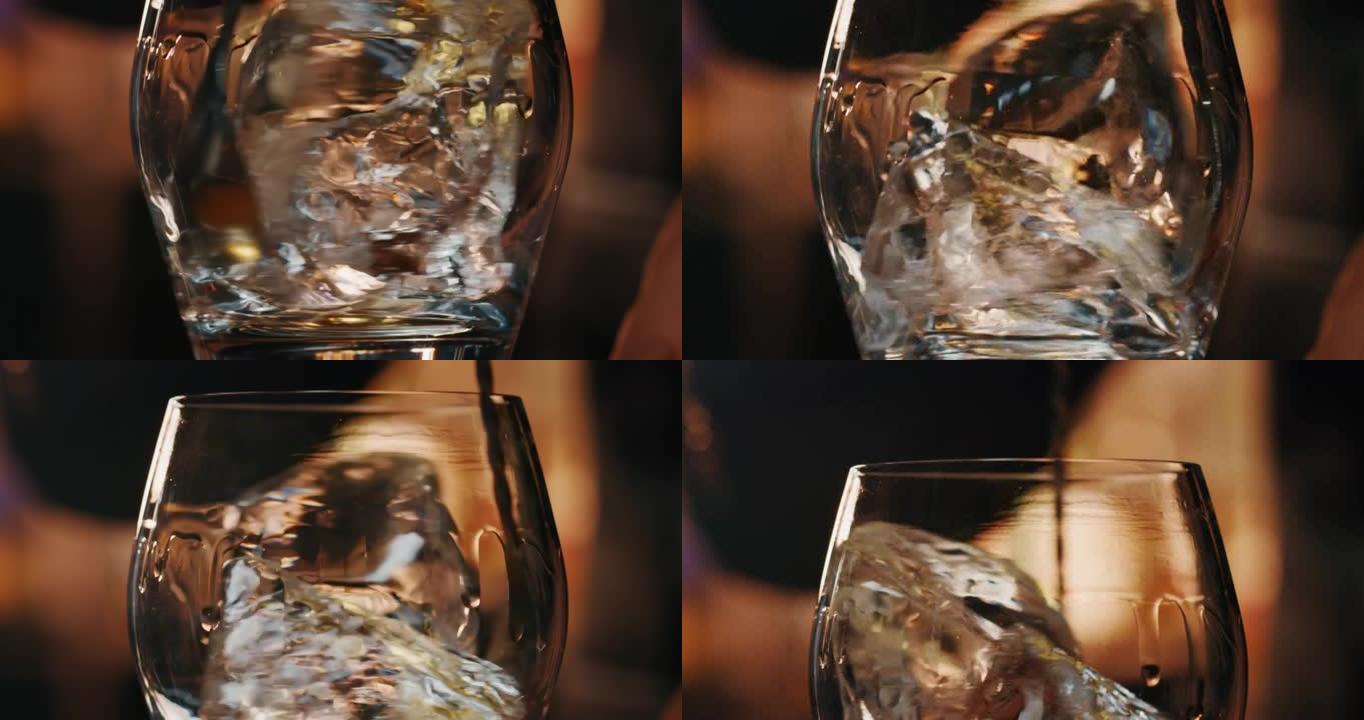 专业调酒师的Macro正在将专业的水晶冰块混合在玻璃杯中，同时在酒吧或迪斯科俱乐部为顾客准备酒精鸡尾