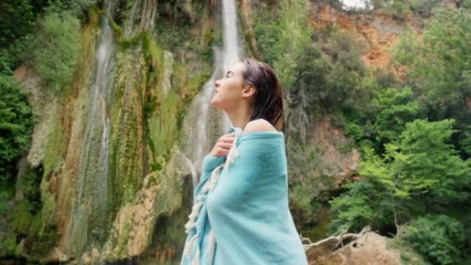 4k视频片段，一名年轻女子用毛巾站在喷泉前