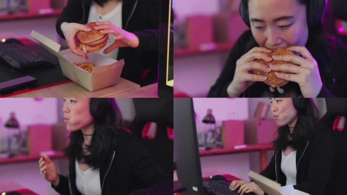 在韩国，玩游戏、吃快餐、亚洲女性一边在电脑上玩在线游戏，一边吃汉堡和薯条。游戏女孩，耳机和流媒体电子