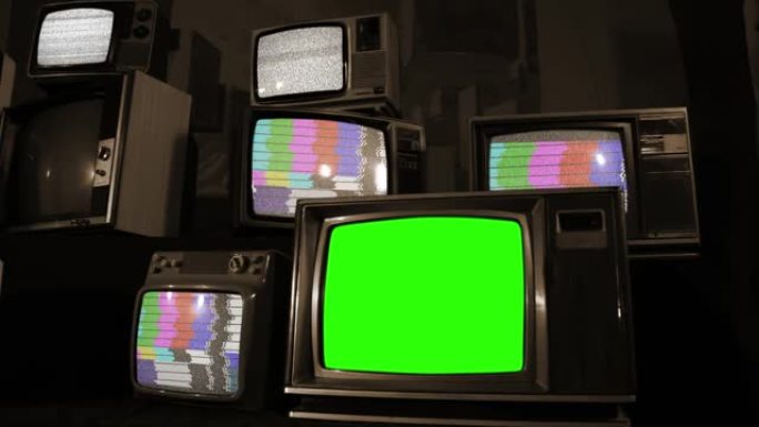 复古电视与绿色色度键屏幕在堆积的复古电视。棕褐色色调。