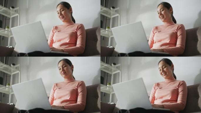 亚洲妇女在家中使用笔记本电脑