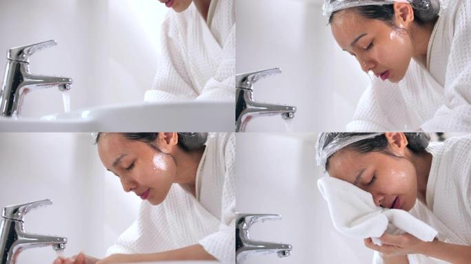 年轻的亚洲妇女在家里的浴室洗脸