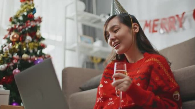 亚洲女性在圣诞节家中通过笔记本电脑进行视频通话