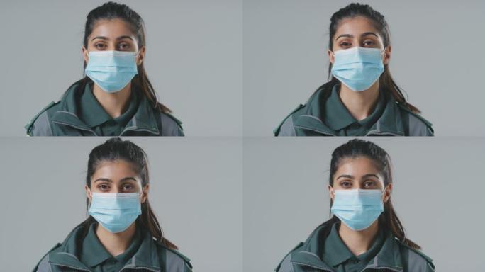 工作室肖像的年轻女性护理人员戴着面具在朴素的背景下