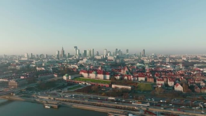 无人机在华沙城市景观天际线上方高高飞行，汽车交通在晴朗的蓝天下沿着维斯拉河移动。