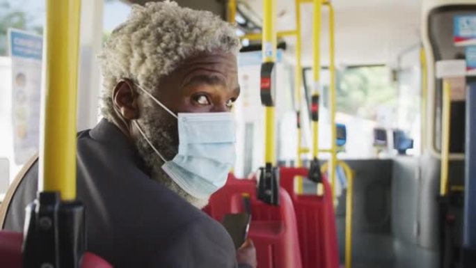 非裔美国高级男子戴口罩乘公共汽车旅行