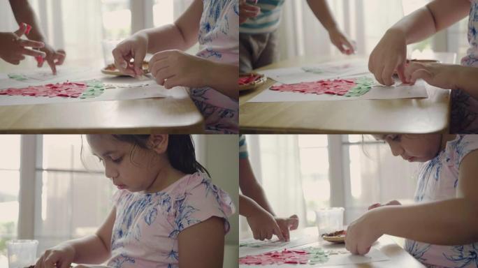 小女儿和儿子，一起坐在家里的桌子上做纸质圣诞装饰品