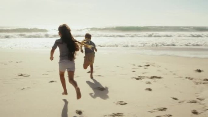 有趣的孩子在沙滩或海沙上奔跑，夏天的天空背景和复制空间。无忧无虑、活跃和顽皮的男孩和女孩孩子享受户外