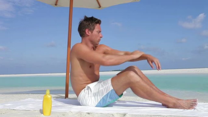 男子在海滩度假时使用防晒霜