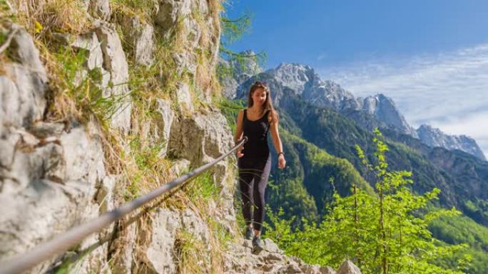 有身体意识的女人在山间小径上徒步旅行