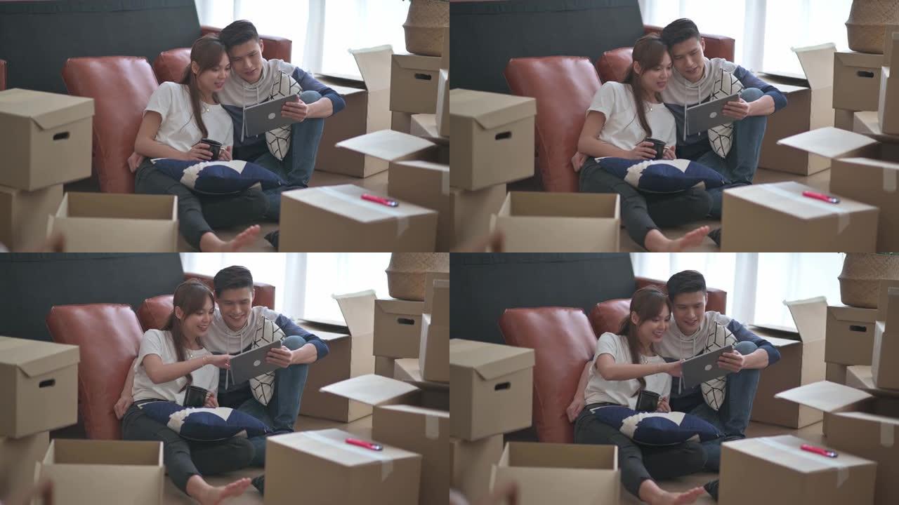 亚洲中国夫妇在客厅搬家房中打开纸箱纸箱后坐在地板上休息