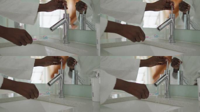 非裔美国迷人女人的手在浴室的刷子上涂抹牙膏