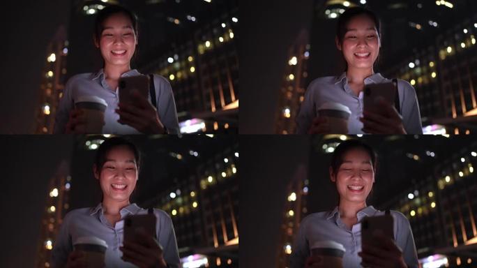 亚洲女商人下班后晚上在城市使用智能手机