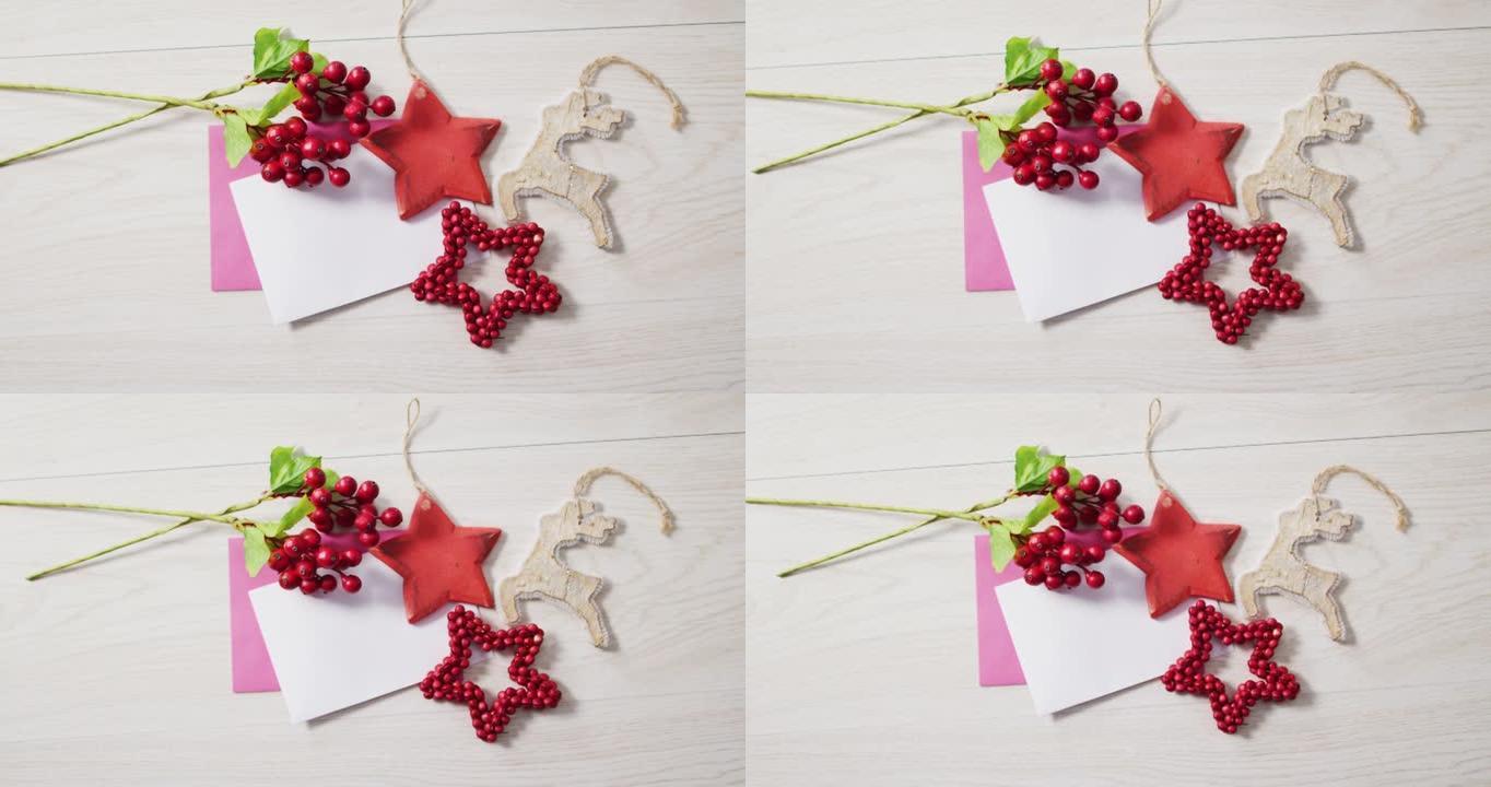 圣诞装饰品视频，木制背景上有白色和粉红色卡片的红色浆果