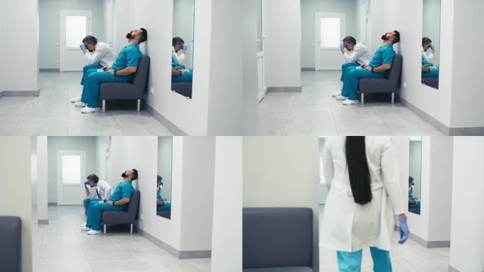 压力大的男医生坐在诊所走廊的沙发上