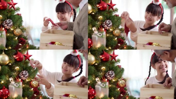 4K UHD手持特写快乐的亚洲女孩和她的祖父多代家庭一起装饰带有装饰品的圣诞树，为节日快乐的冬天做准