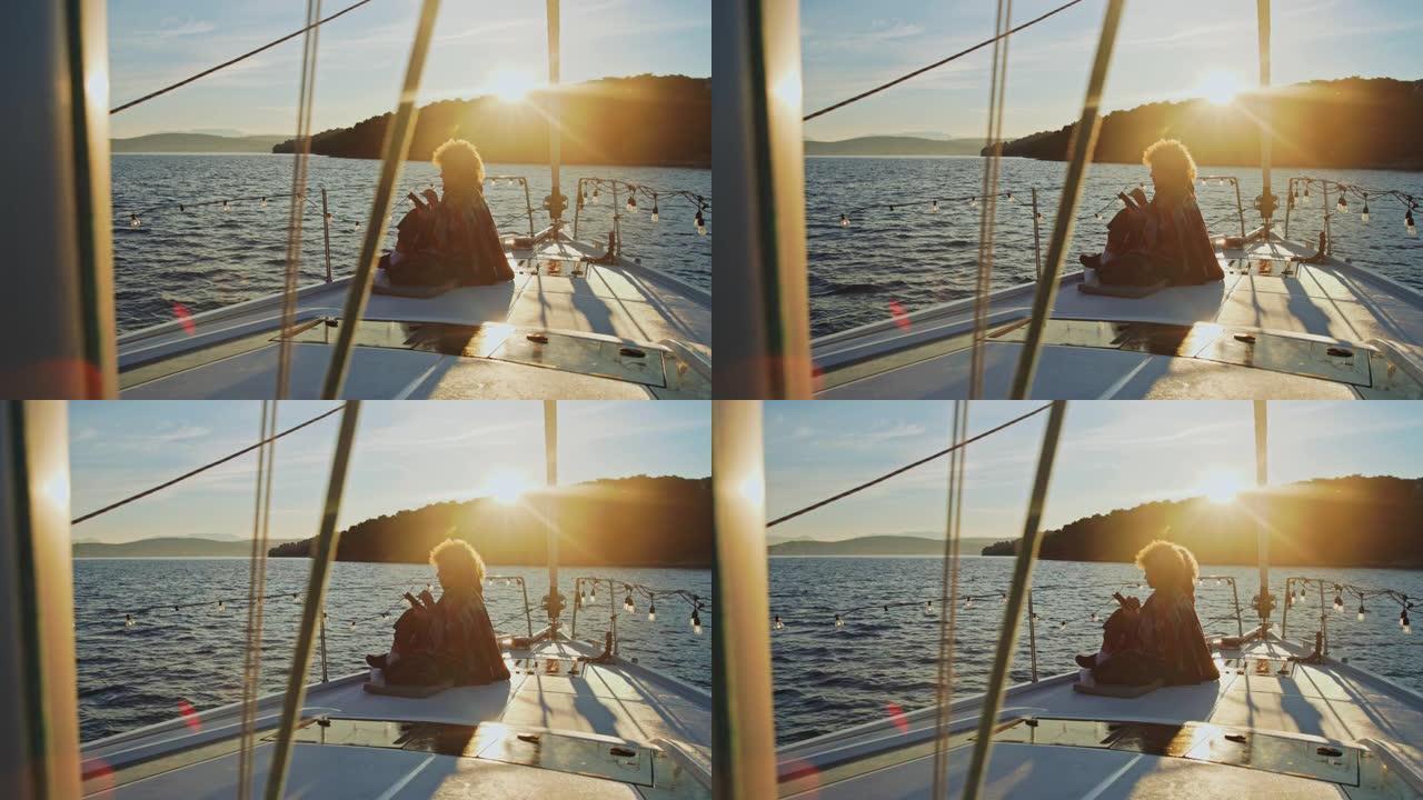 SLO MO两名年轻女子在日出时坐在帆船的甲板上