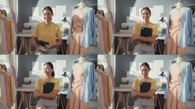开朗的专业亚洲女士时装设计师，休闲手持数字平板电脑微笑着看着相机，对她的商店充满信心。裁缝女学生为她