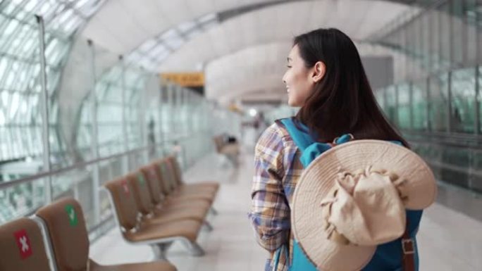 亚洲旅游妇女走过机场航站楼在机场旅行，慢动作