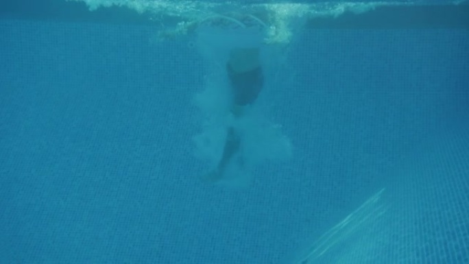 家庭暑假时，父亲带着充气戒指跳入游泳池的水下镜头