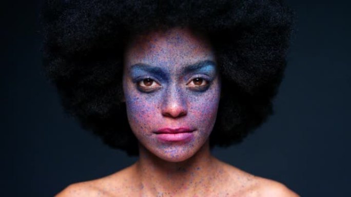 黑人女性在工作室的创意化妆和肖像，带有非洲和严肃的面孔，背景为模型。思考、沉思和专注于彩色化妆品飞溅