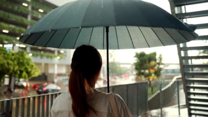 女商人在雨中撑伞时感到难过