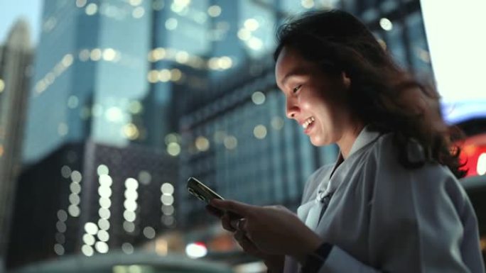 夜间在城市使用智能手机的女商人