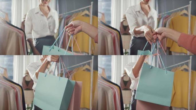 特写开朗的年轻亚洲女士购物新装礼品拿起购物袋后在布店购买布料和连衣裙。购物狂女孩，特价，活动生活理念