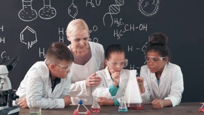 女教师和学童正在观察化学反应