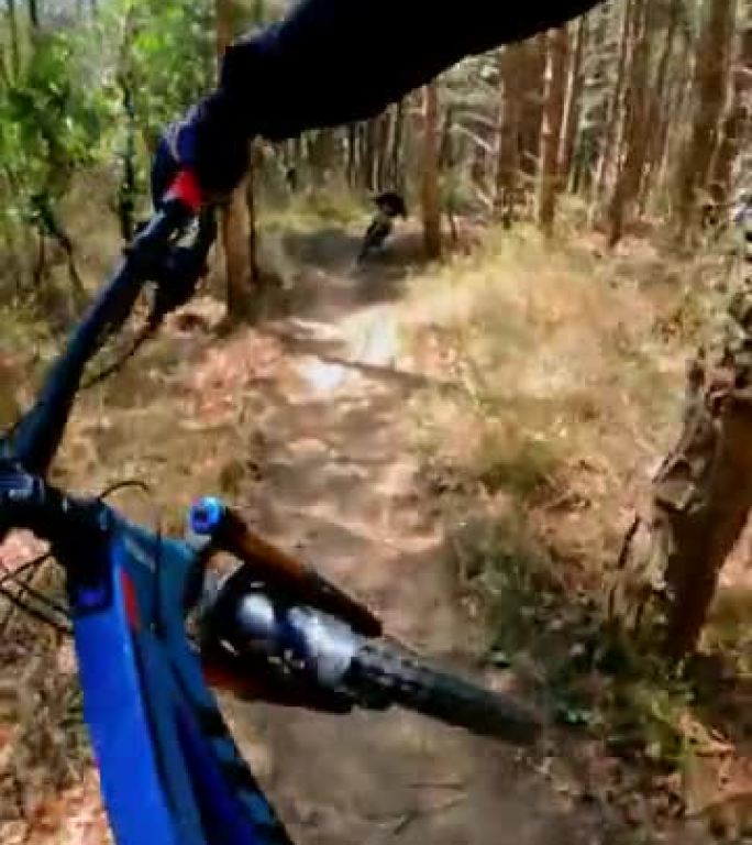 一名下坡山地自行车手在森林中超速行驶的垂直视频镜头