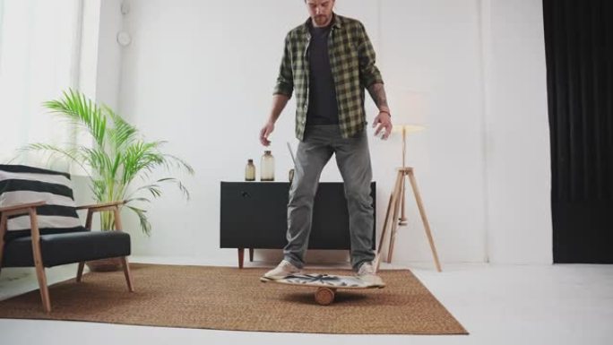 棕色头发的男人在平衡板上平衡室内
