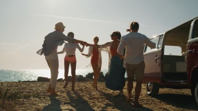 一群年轻的多民族朋友的慢动作来到海边的海滩上，玩得很开心，弹吉他，唱歌和跳舞，阳光明媚。