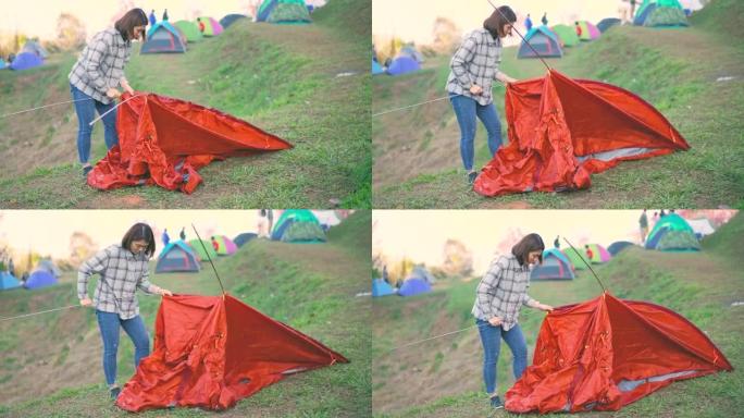 女旅行者在山上的露营地搭建帐篷