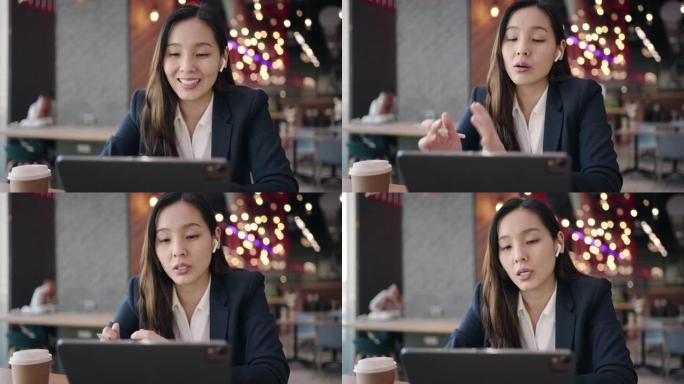 女商人在咖啡馆的数字平板电脑上进行视频通话会议，进行视频通话以与同事联系