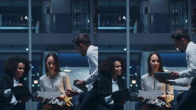 垂直剪辑: 晚上在大城市办公室工作的多元化经理团队。同事交谈，讨论商机，评估财务报告，计划投资策略。