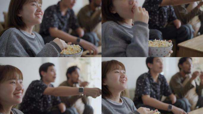 亚洲男子手臂残疾和他的朋友一起在电视上看电影的特写