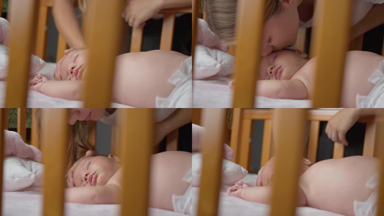 SLO MO深情的年轻母亲在婴儿床上睡觉时亲吻她的婴儿男孩