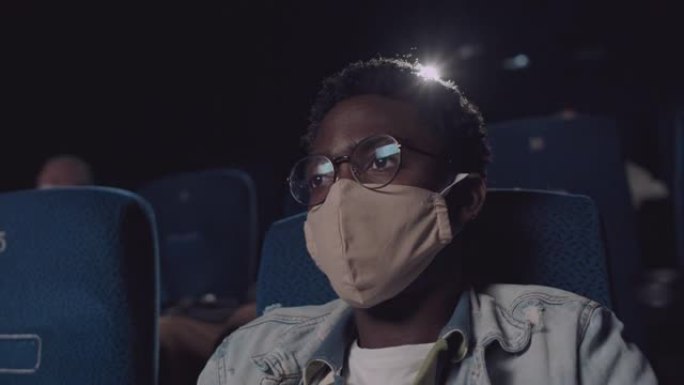戴着面具的黑人在电影院看电影