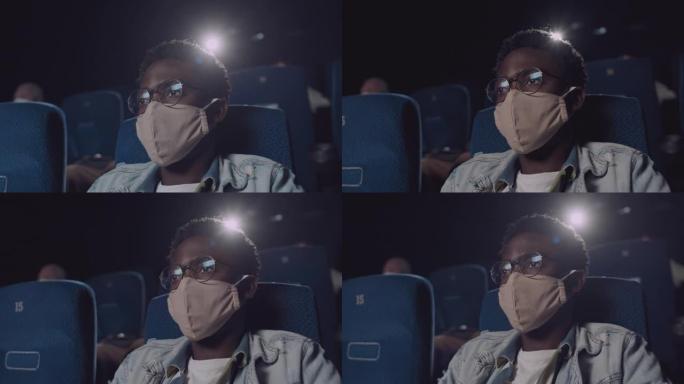 戴着面具的黑人在电影院看电影