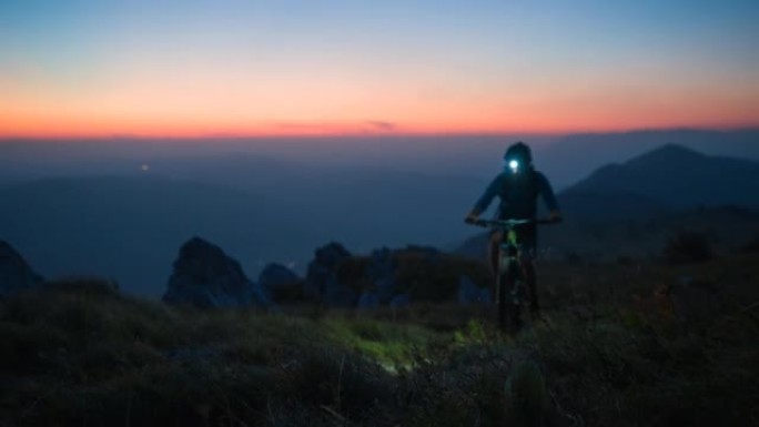 坚定的职业男自行车手在黄昏时在落基山小径上坡骑行