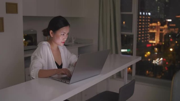 亚洲认真的女商人在家从事计算机之夜