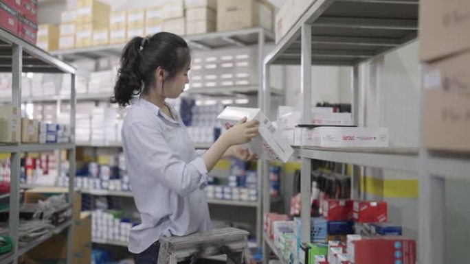 亚洲年轻女性仓库工人，配有平板电脑和仓库清单。仓库概念