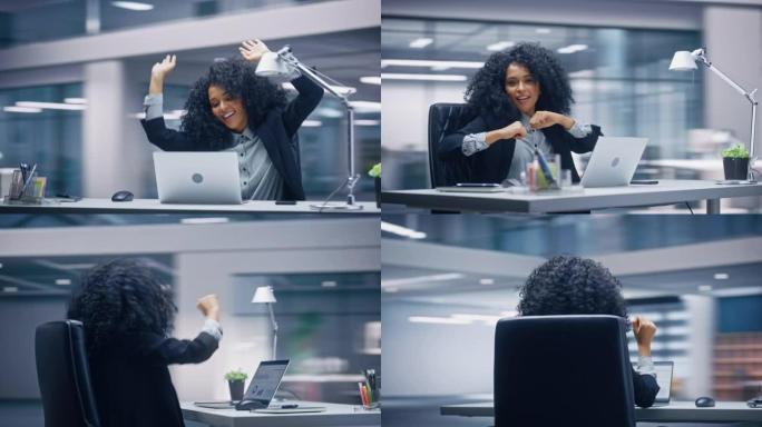 360学位办公室: 黑人女商人坐在办公桌前跳舞和微笑。美丽的女性专家在笔记本电脑上庆祝成功的电子商务