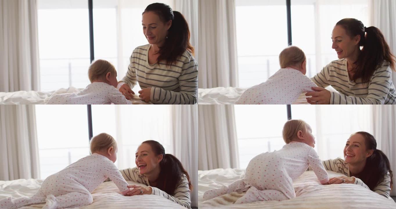 白人母亲在家里的床上和婴儿玩耍时微笑着