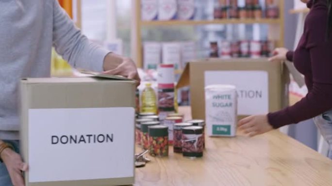 4k视频片段，一对夫妇在将食物放入盒子之前检查要捐赠的食物