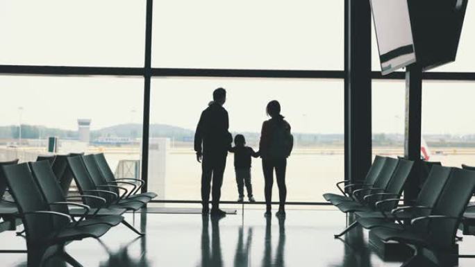登机前，家人站在机场的窗户附近