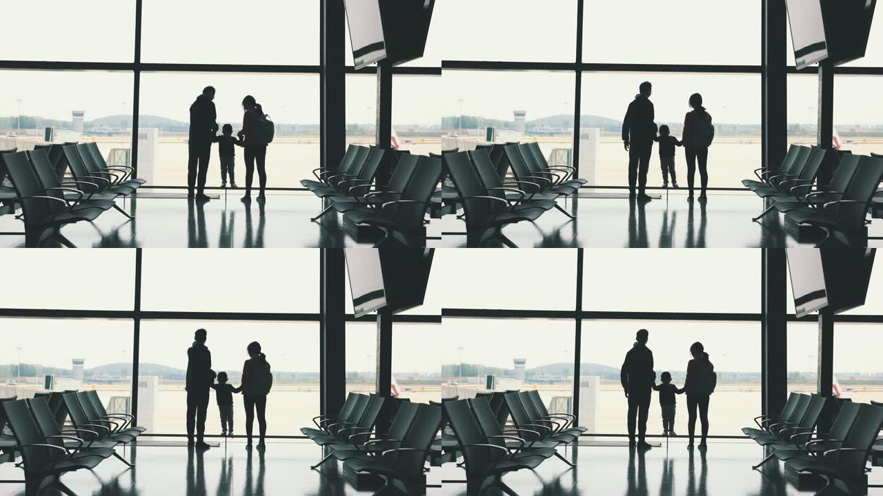 登机前，家人站在机场的窗户附近