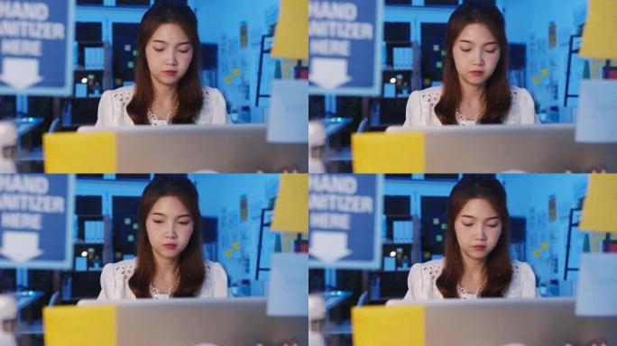 自由职业者亚洲女性使用笔记本电脑在新的普通家庭办公室努力工作。