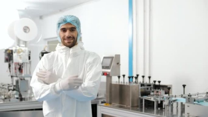 医疗制造商生产线上穿着PPE套装的年轻人的肖像